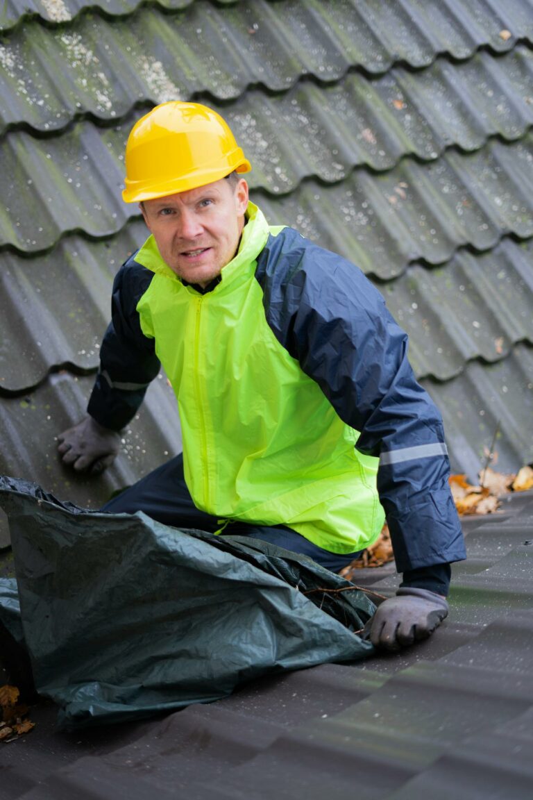 A construction worker wearing safety gear inspects a roof for maintenance.